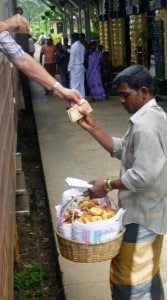 Buying food through the train window - dhal cakes, chillies, and samosas