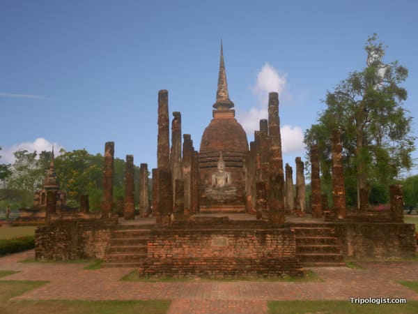 A Buddha statue sits in the middle of the ruins of Wat Sa Si in Sukhothai Historical Park.