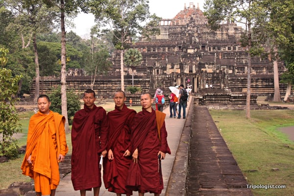 Four Buddhist monks pose in front of a temple at Angkor Thom.